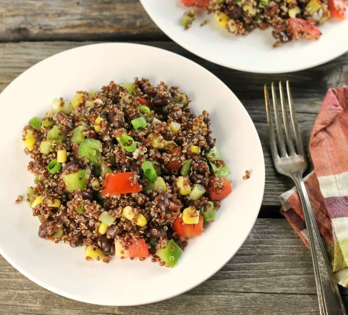 Black bean quinoa salad a hearty and healthy salad filled with chopped tomatoes, green pepper, and green onions.