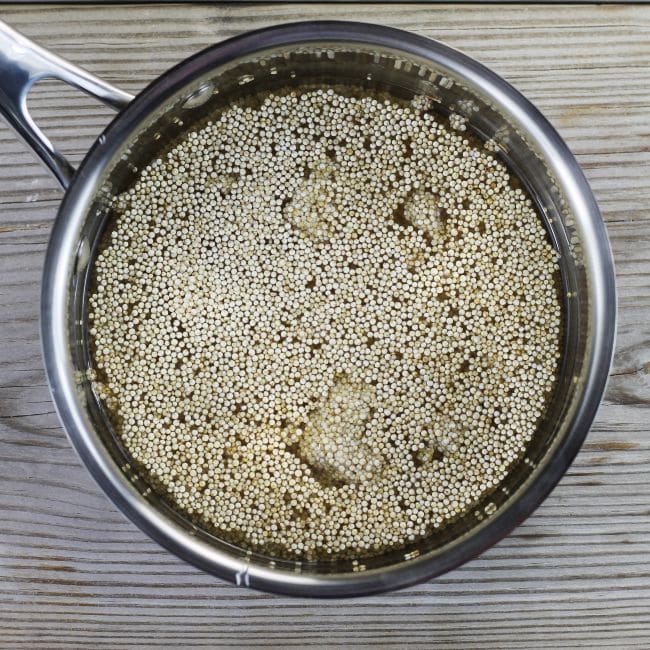 Water and quinoa in a saucepan.