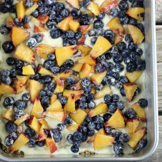 Blueberry and peaches are sprinkled over top of the cream cheese.