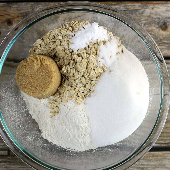 Flour, brown sugar, and oats in a glass bowl.