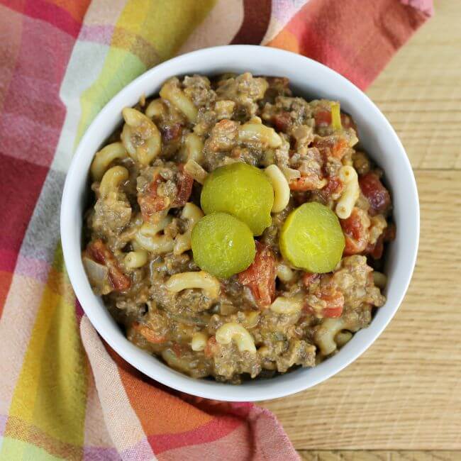 Looking down at a bowl filled with a casserole topped with pickle slices.