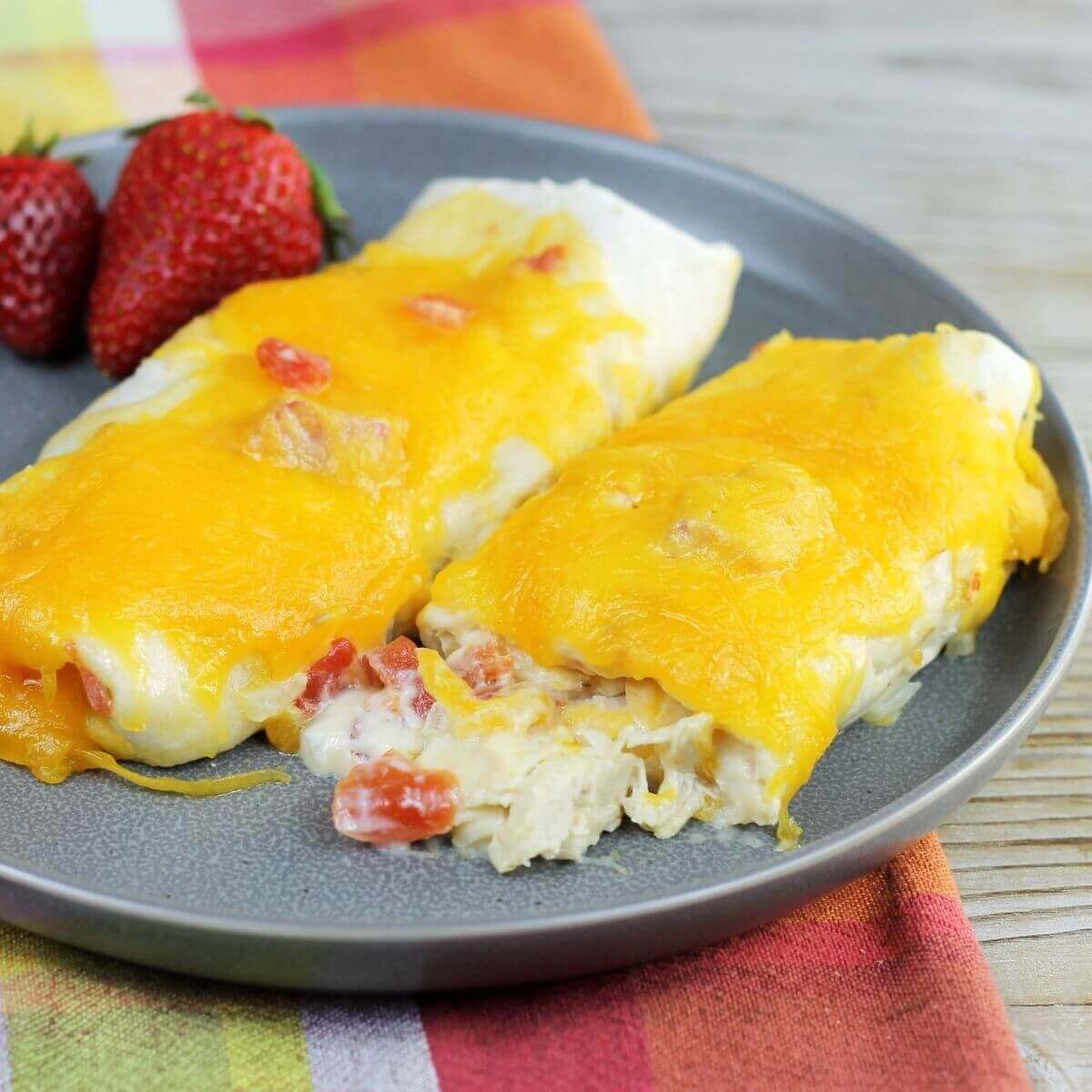 Side angle view of two chicken enchiladas on a gray plate.