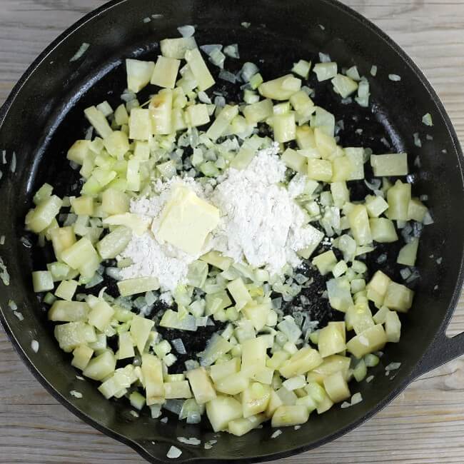 Flour and butter are added to the skillet with the cooked vegetables.