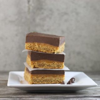Peanut Butter Caramel Bars with a peanut butter cookie crust topped with a gooey caramel filling on top of all this a thick layer of chocolate peanut butter frosting. 
