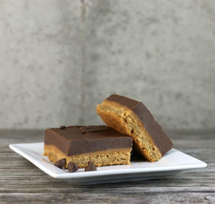Peanut Butter Caramel Bars with a peanut butter cookie crust topped with a gooey caramel filling on top of all this a thick layer of chocolate peanut butter frosting. 