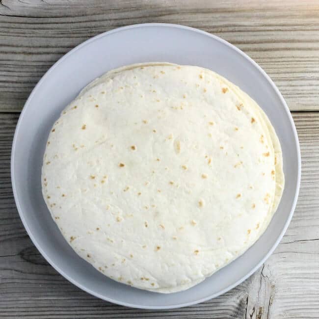 Looking down a plate with a stack of flour tortillas.