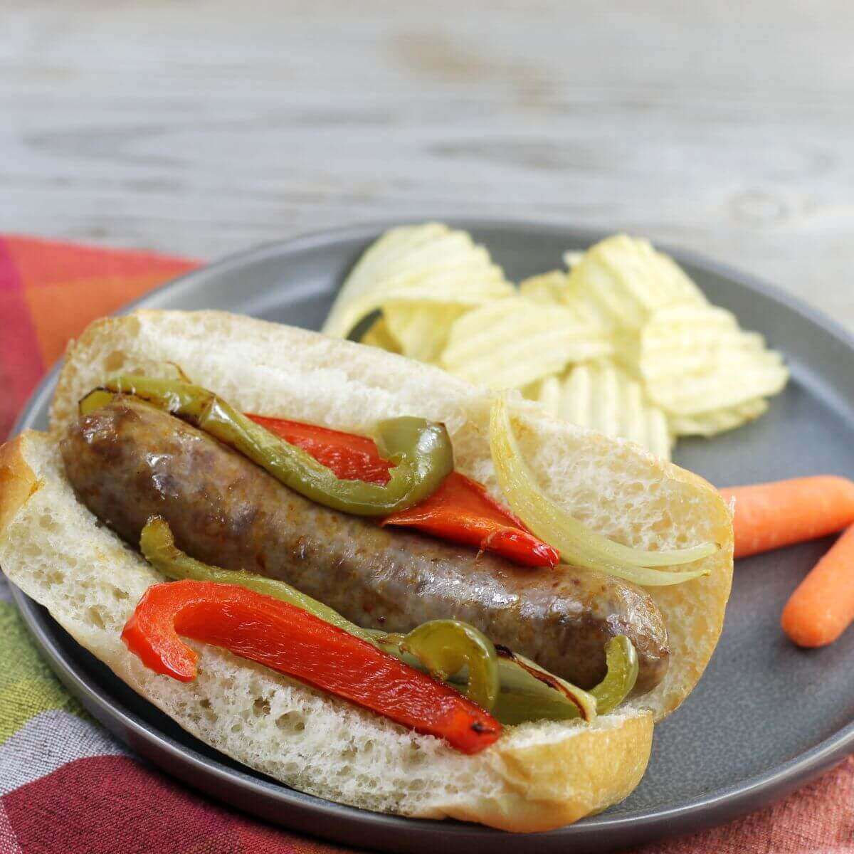 A side angle view of an Italian sausage in a bun  with peppers and onion. 