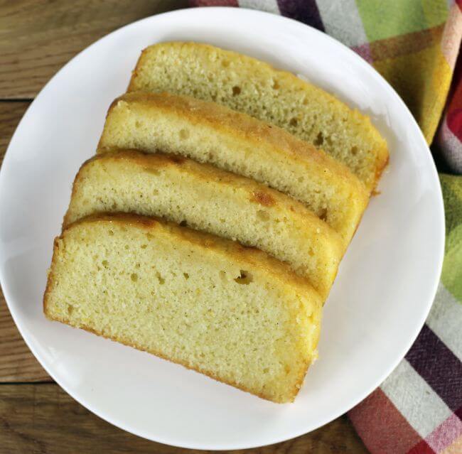 Looking down at slices of orange bread on a white plate.