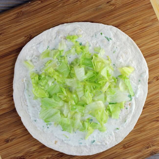 Lettuce is added to the wrap.