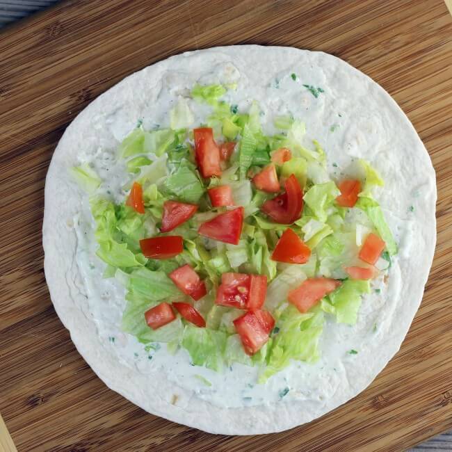 Tomatoes are sprinkled over top of the lettuce.