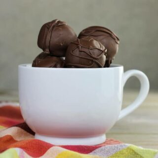 Side view of Chocolate brownie truffles in a white mug.