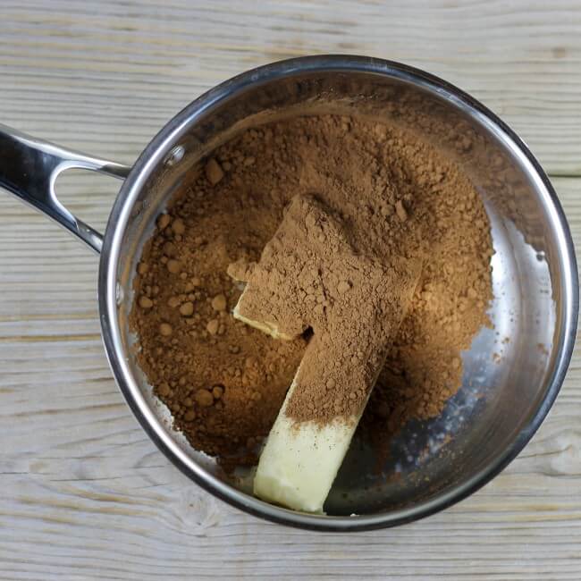 Cocoa and butter are added to a large saucepan.