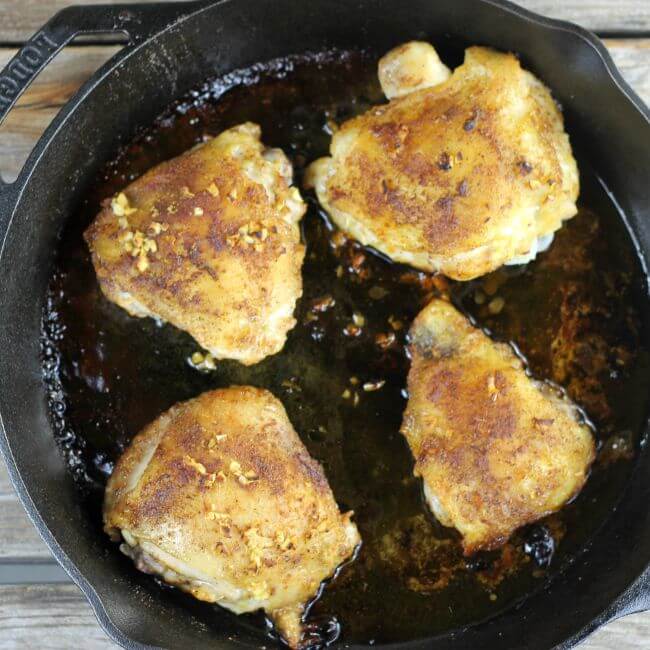 Chicken thighs in a skillet.