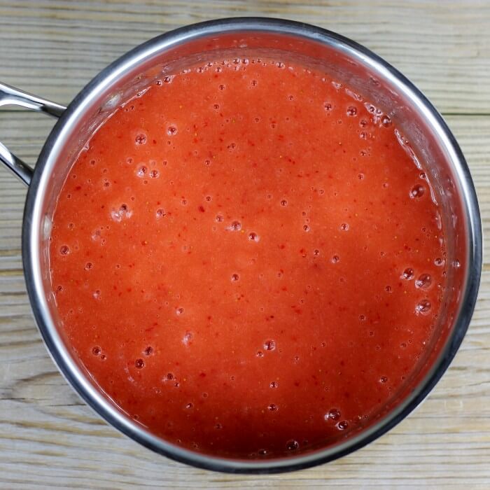 A medium saucepan with blended fruit in it.