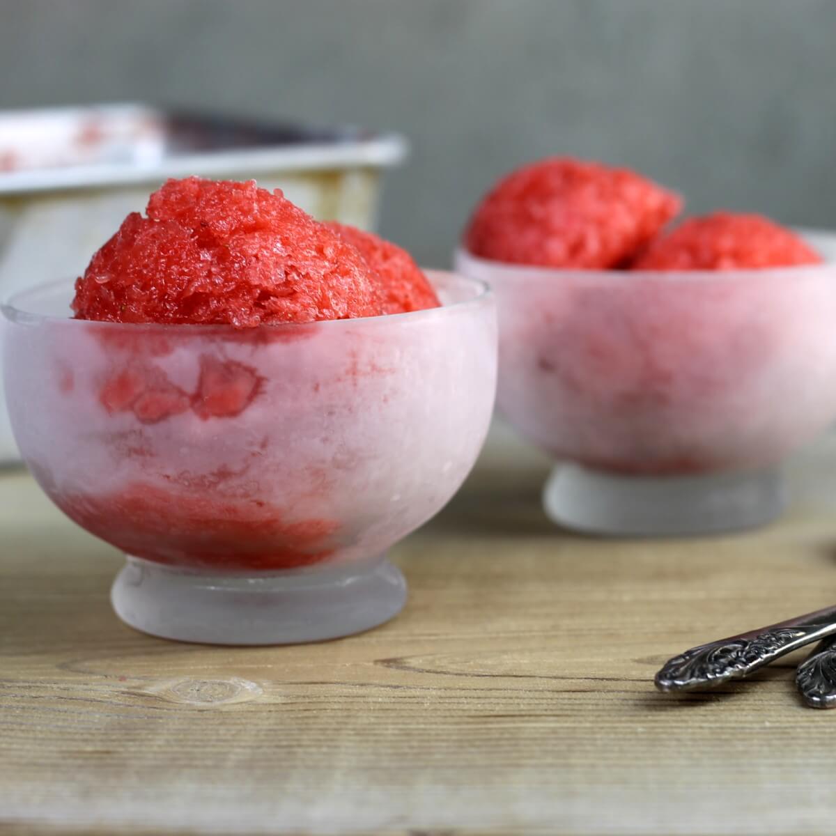 A side view of two bowls of strawberry rhubarb sorbet.