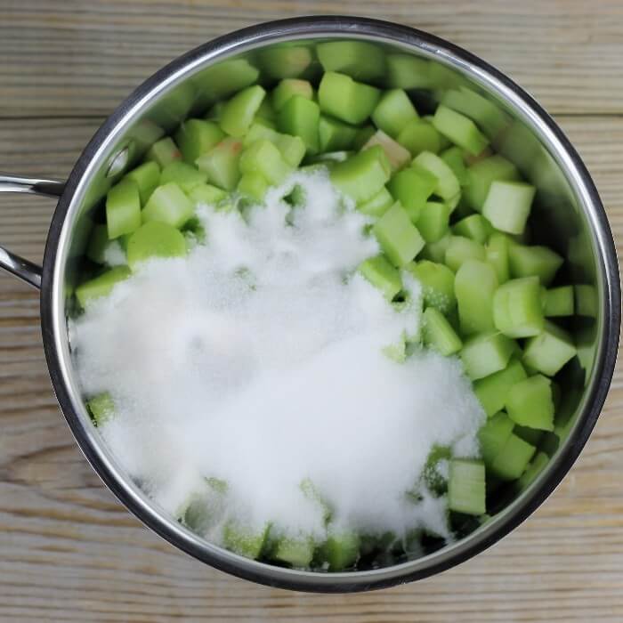 Sugar and rhubarb are added to a medium saucepan.