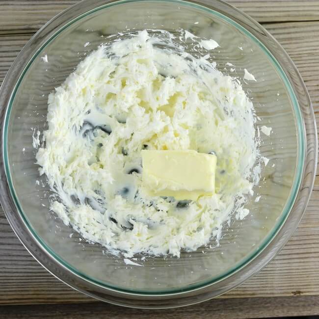 Cream cheese and butter in a glass bowl.