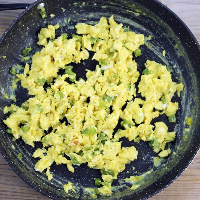 Looking down at a skillet with scrambled eggs.