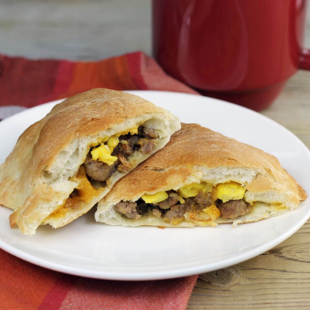 A side view of a breakfast calzone on a white plate.