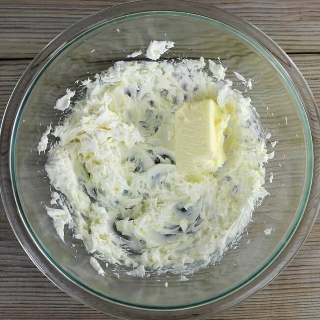Butter is added to the cream cheese bowl.