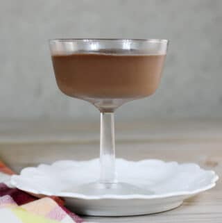 A side view of a dessert dish with pudding on a white plate.