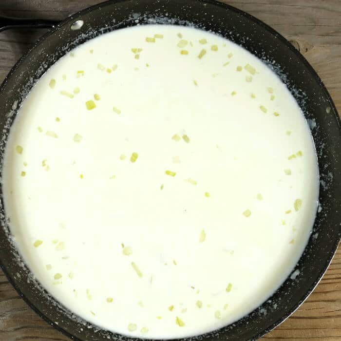 Cream and broth are added to the skillet.