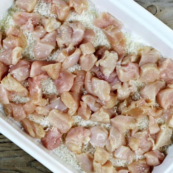 Chicken is placed over the top of the rice in the baking dish. 