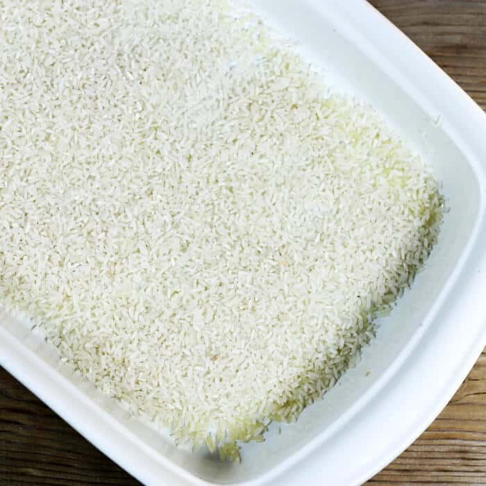 Rice is added to the bottom of the baking dish.