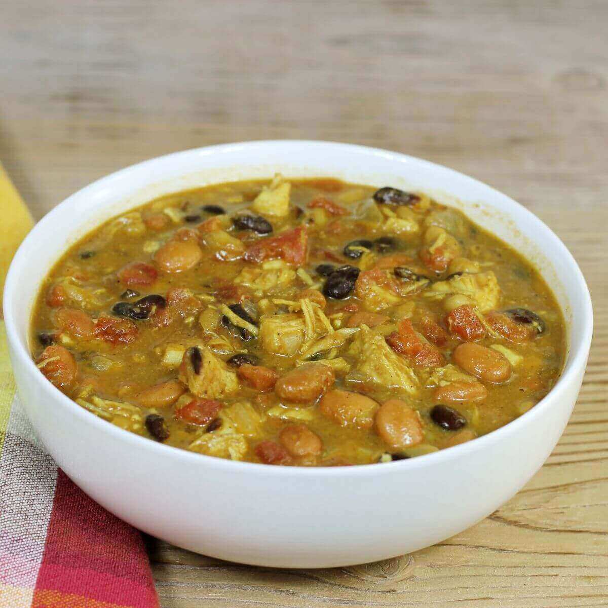 A side of a white bowl of chicken chili. 