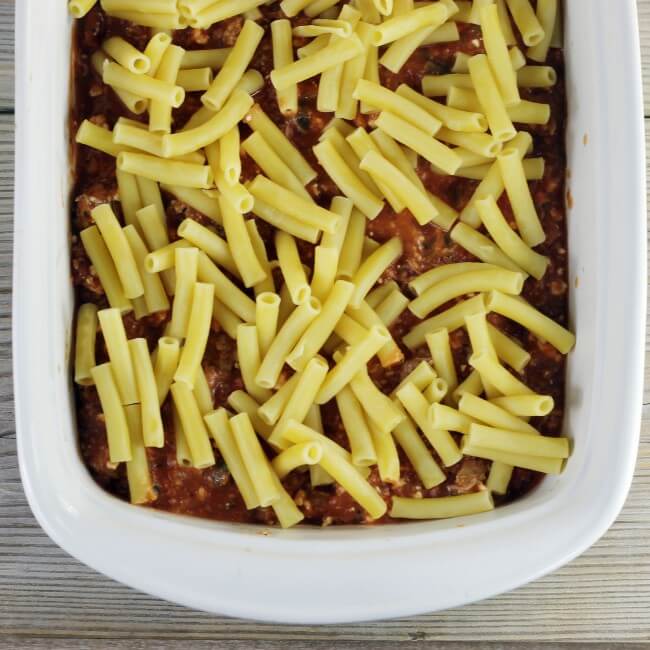 Ziti noodles are placed on top of the meat sauce. 