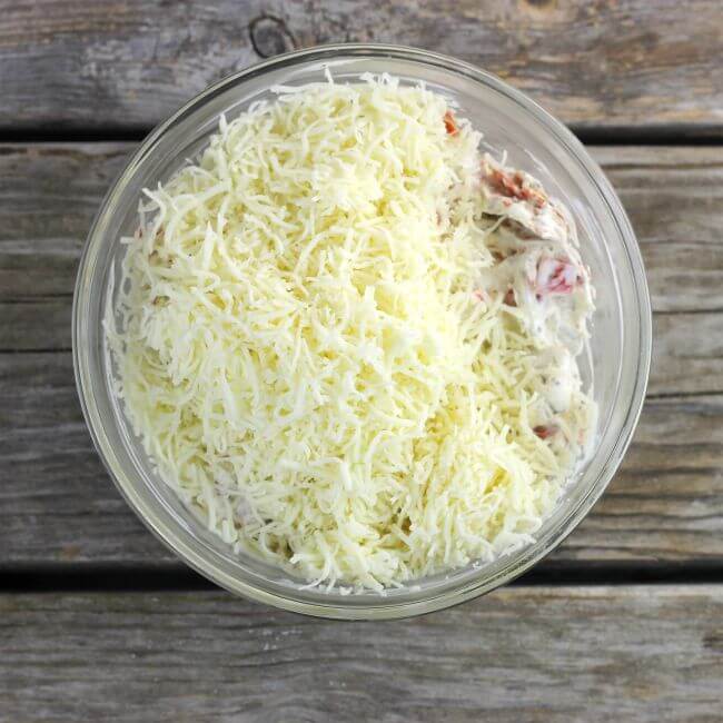 Mozzarella in glass bowl with pepperoni dip.