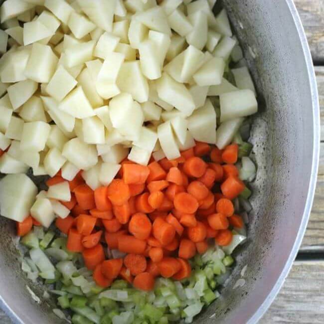 Carrots, potatoes, onions, and celery in a Dutch oven.