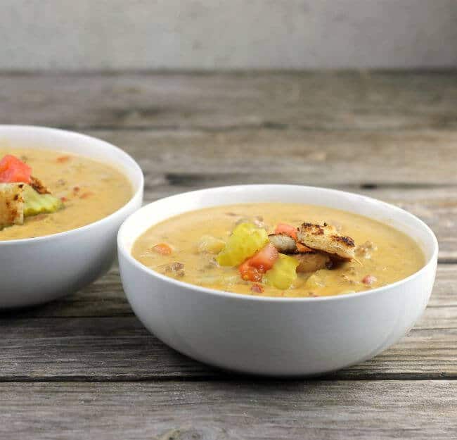 Cheeseburger soup in 2 white bowls.