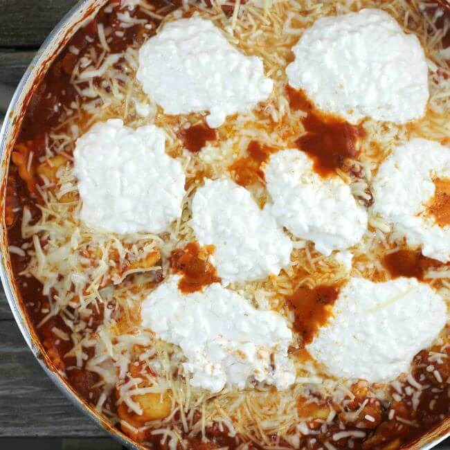 Cottage cheese and mozzarella cheese on top of skillet lasagna.