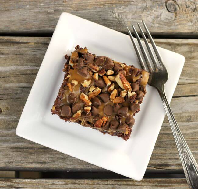 Turtle Dump Cake with a fork on a white plate.