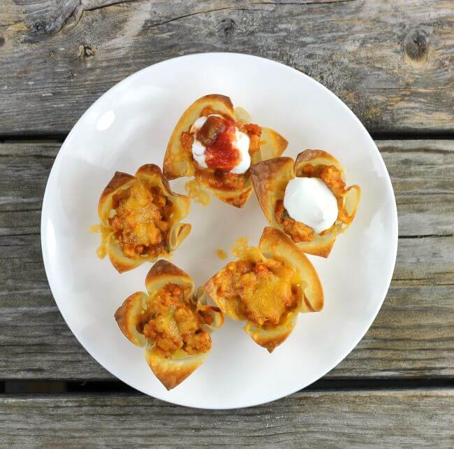 Wonton taco cups on a white plate.