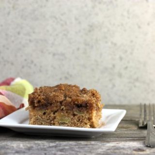 Apple cake on a white plate with plaid napkin and fork