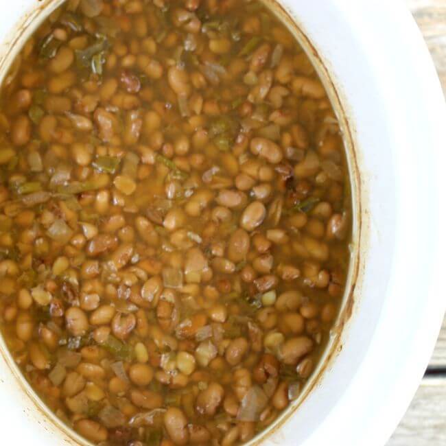 Cooked beans in a white slow cooker.