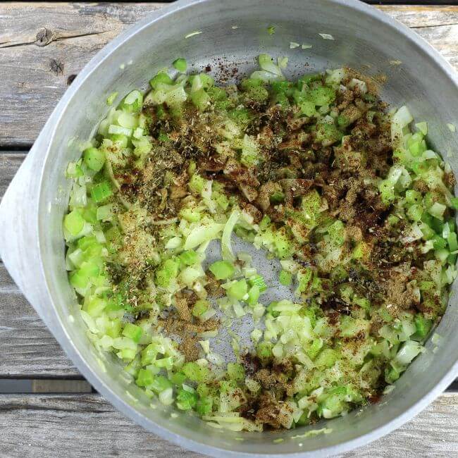 Seasoning on top of cooked celery and onion in a Dutch oven.