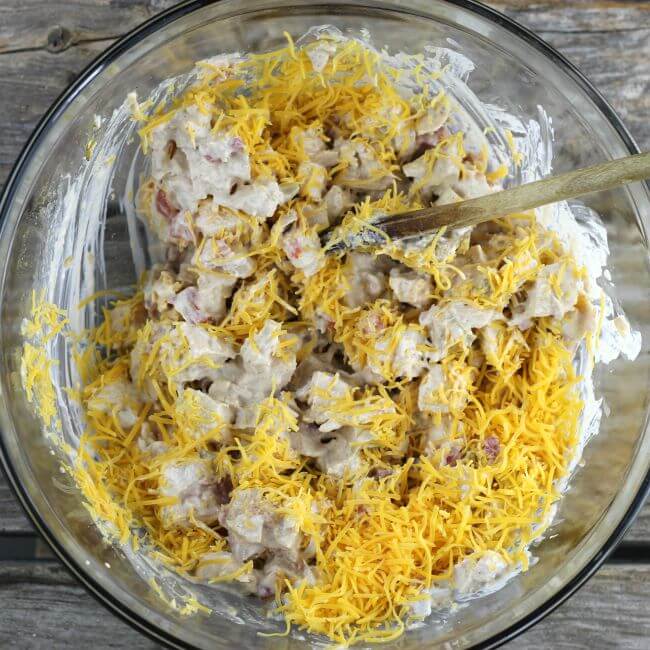 Chicken enchilada filling with cheese in a glass bowl.