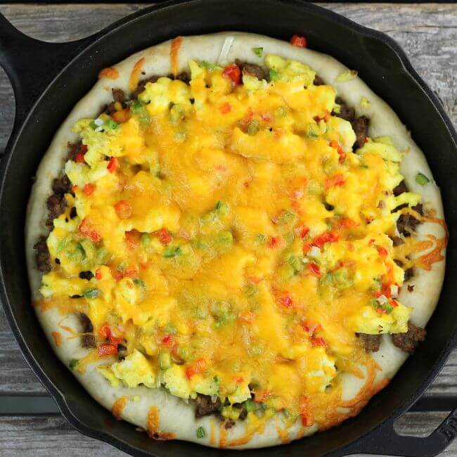 Baked sausage breakfast pizza in a cast-iron skillet.