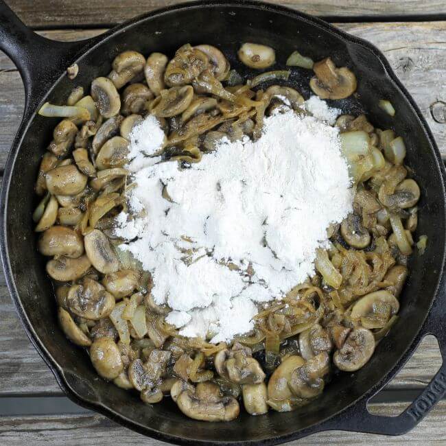 Flour added to cooked onions and mushrooms.