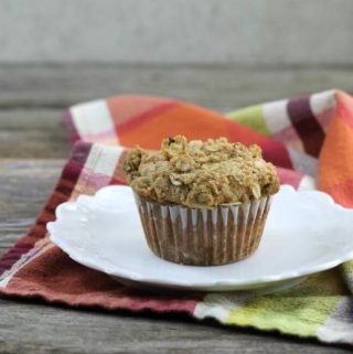 Best banana muffin on a white plate set on a napkin.