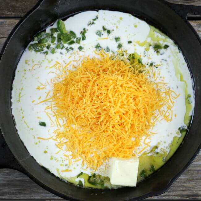 Cream and cheese added to the green pepper in the cast-iron skillet