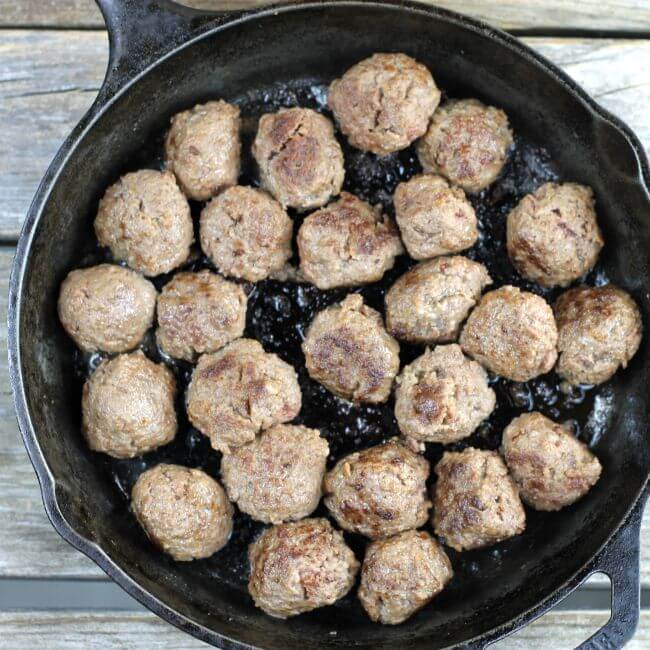 Cooked meatballs in a skillet.