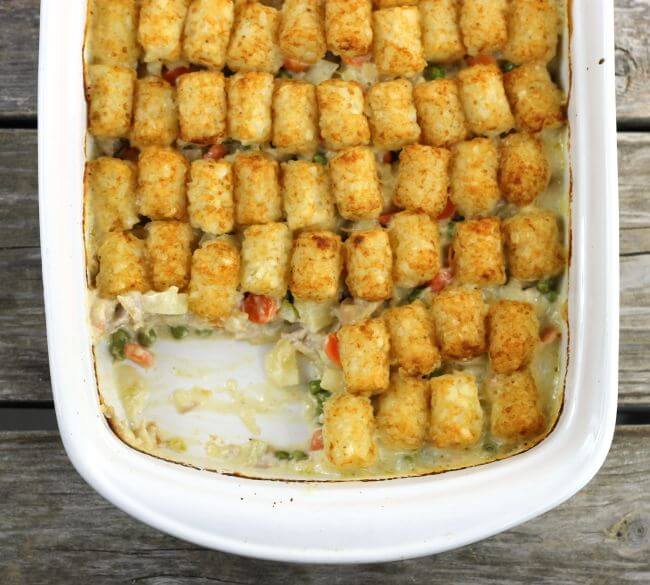 Tater Tot Chicken Casserole in baking pan with one serving removed.