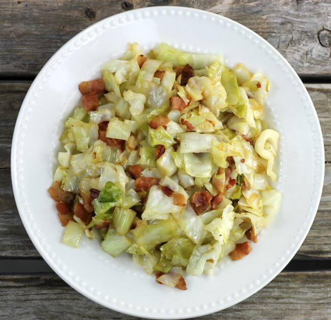 Fried cabbage with bacon in a white bowl