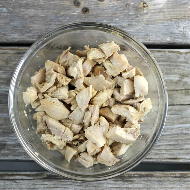 Cooked chicken pieces in a glass bowl.