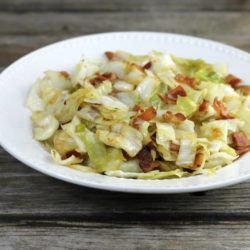 Side view of fried cabbage in a white bowl.
