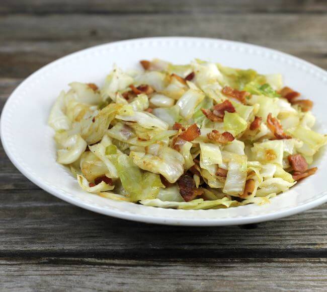 Side view of fried cabbage in a white bowl.